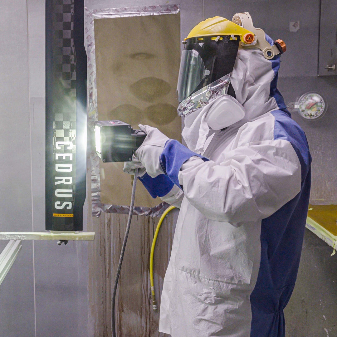 Person in protective suit and mask using a machine with 'CEDRUS' branding in a laboratory setting.