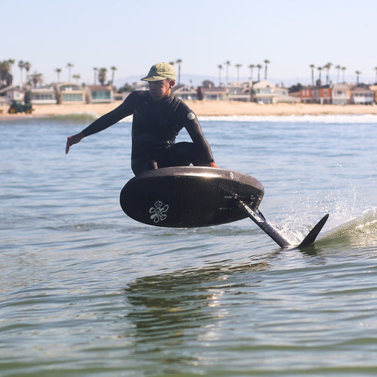 Foiler executing an extreme turn on a wave, elevating the surf experience on a Cedrus Evolution Surf hydrofoil mast, blending speed with precision.