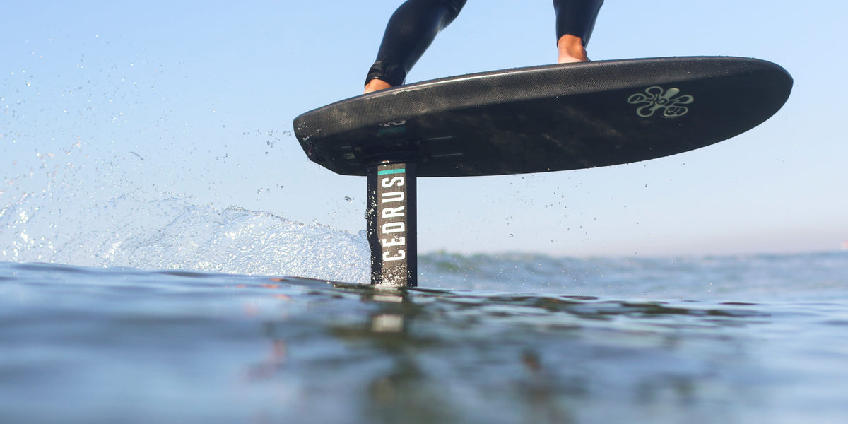 Close-up action shot of a hydrofoiler in motion, where the high-quality Cedrus mast cuts through the water with precision. The wake trailing behind showcases the mast's exceptional strength and the engineering quality that allows for both high-speed performance and enduring stability in the water