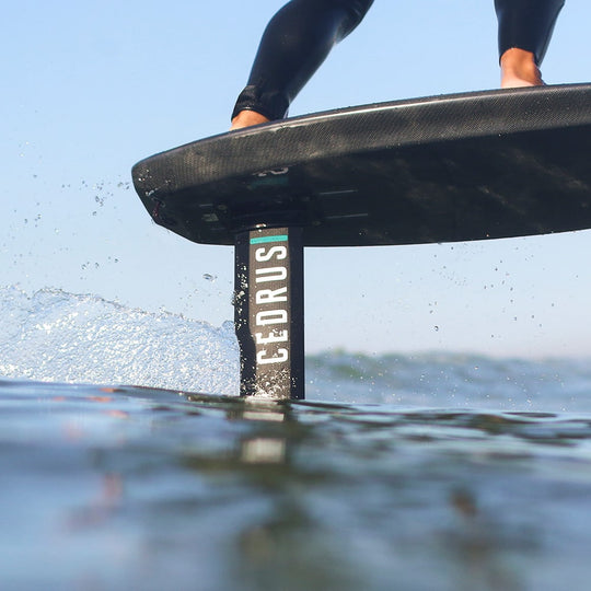 Close-up action shot of a hydrofoiler in motion, where the high-quality Cedrus mast cuts through the water with precision. The wake trailing behind showcases the mast's exceptional strength and the engineering quality that allows for both high-speed performance and enduring stability in the water