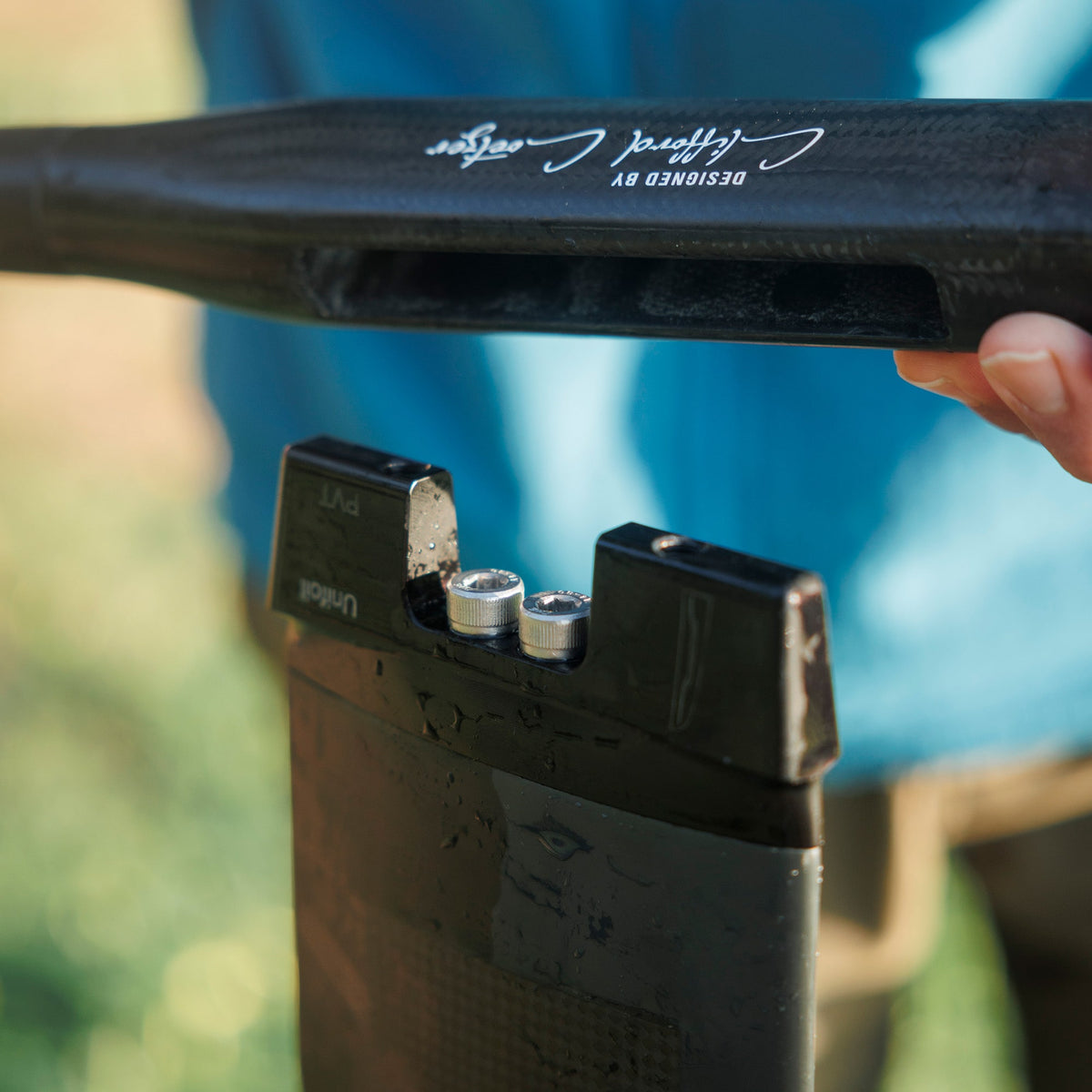 Detail showing a hand installing a Unifoil foil onto a Cedrus Evolution mast with a Unifoil adapter designed an engineered by Cedrus to fit seamlessly with limitless possibilities to surf any foil brand with a Cedrus mast