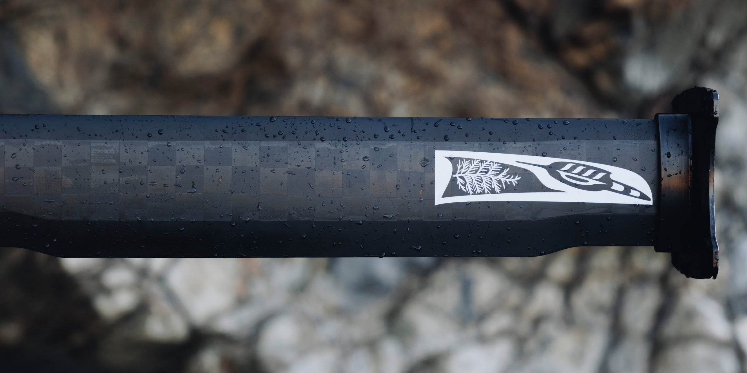 Detail of a Cedrus hydrofoil mast showcasing the logo, a combination of an orca's dorsal fin, a cedar bow, and an eagle feather, symbolizing the art of flight on water. The design, created by a British Columbia First Nations artist, captures the essence of Cedrus' reverence for natural elements and the seamless fusion of advanced hydrofoil technology with the timeless elegance of the ocean's inhabitants.